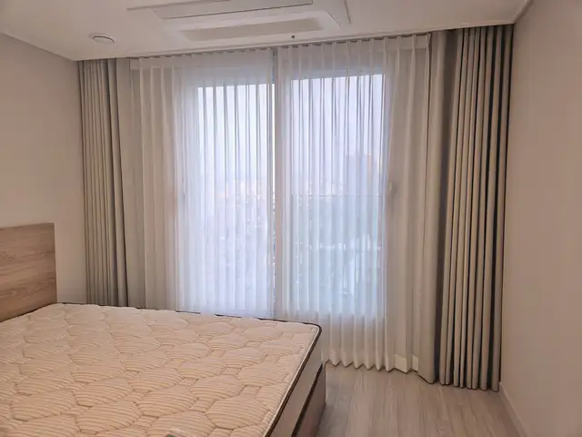 빈 침실 창에 맞춤 제작한 암막 커튼